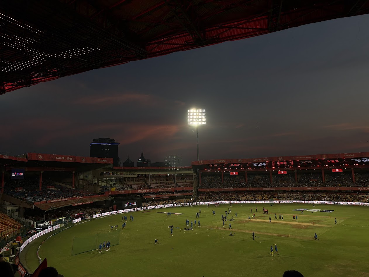 M. Chinnaswamy Stadium under floodlights at dusk during IPL 2025
